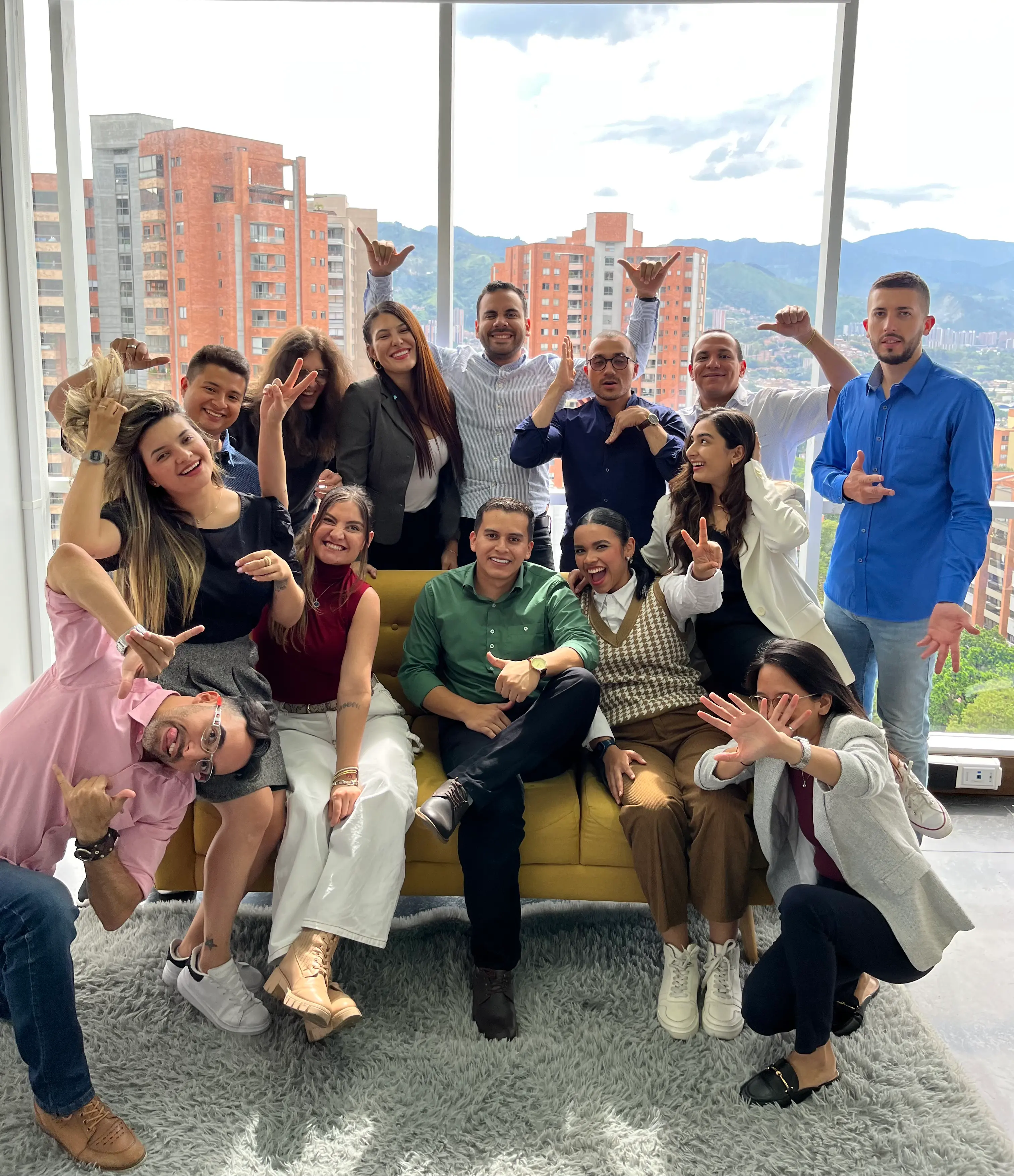 The Callbox team posing together on a yellow sofa in a bright office overlooking the city