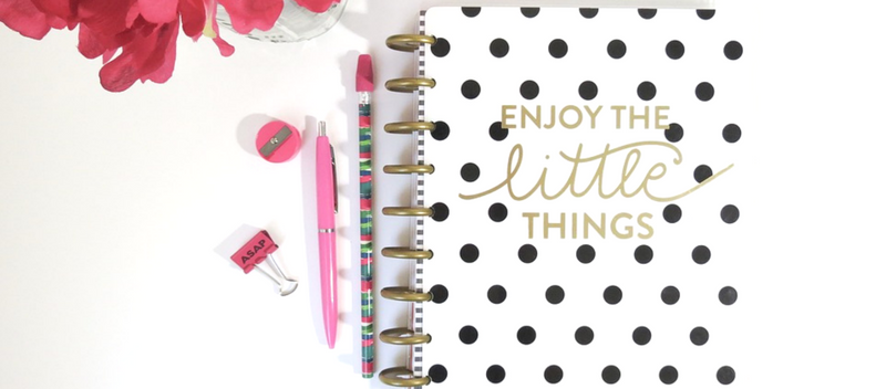 An image of a notebook planner with a design that says "Enjoy the little things"